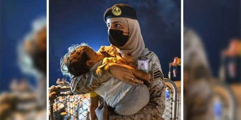 إغفاءة الأمان.. مجندة سعودية تحتضن طفلاً لدى إجلائه من السودان